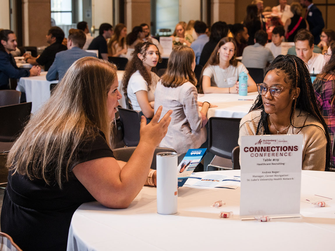 A woman talks to a college student during a roundtable networking event